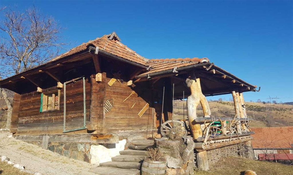 Tradicionalna drvena seoska kuća sa tremom i pogledom na prirodu