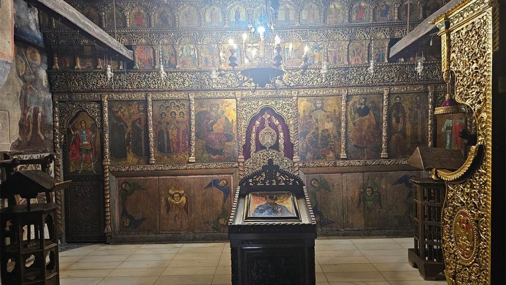 Unutrašnjost manastirske crkve Svetog Nauma sa ikonostasom, ikonama i centralnim postoljem za ikonu pod lusterom.